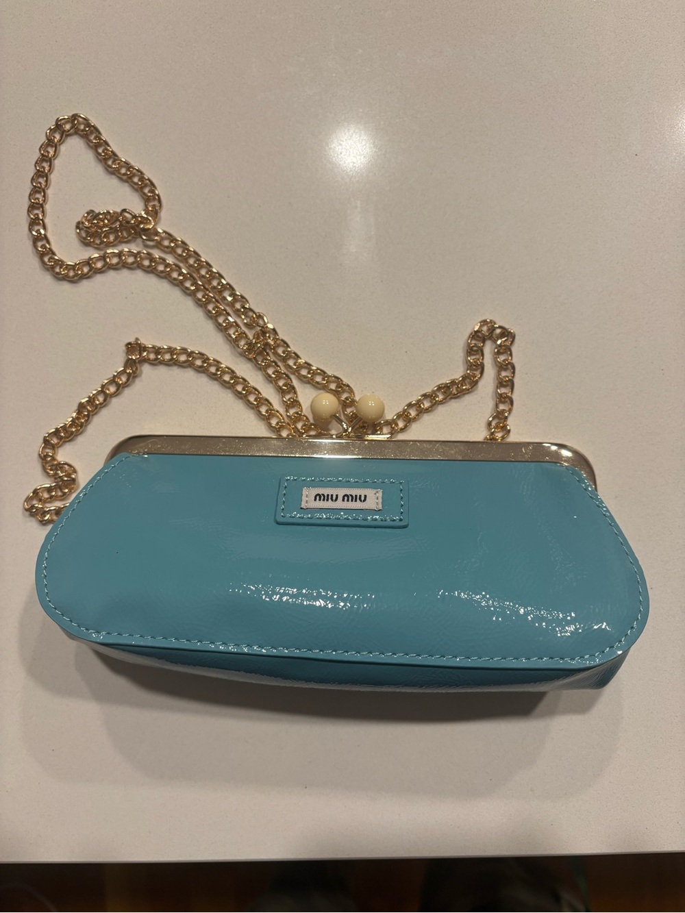 Miu Miu Kisslock Chain Clutch in Aqua Blue.